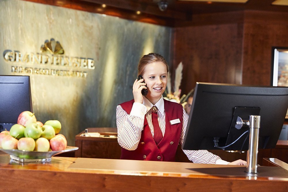 Mitarbeiterin am Empfang des Grand Elyseé Hotel in Hamburg telefoniert